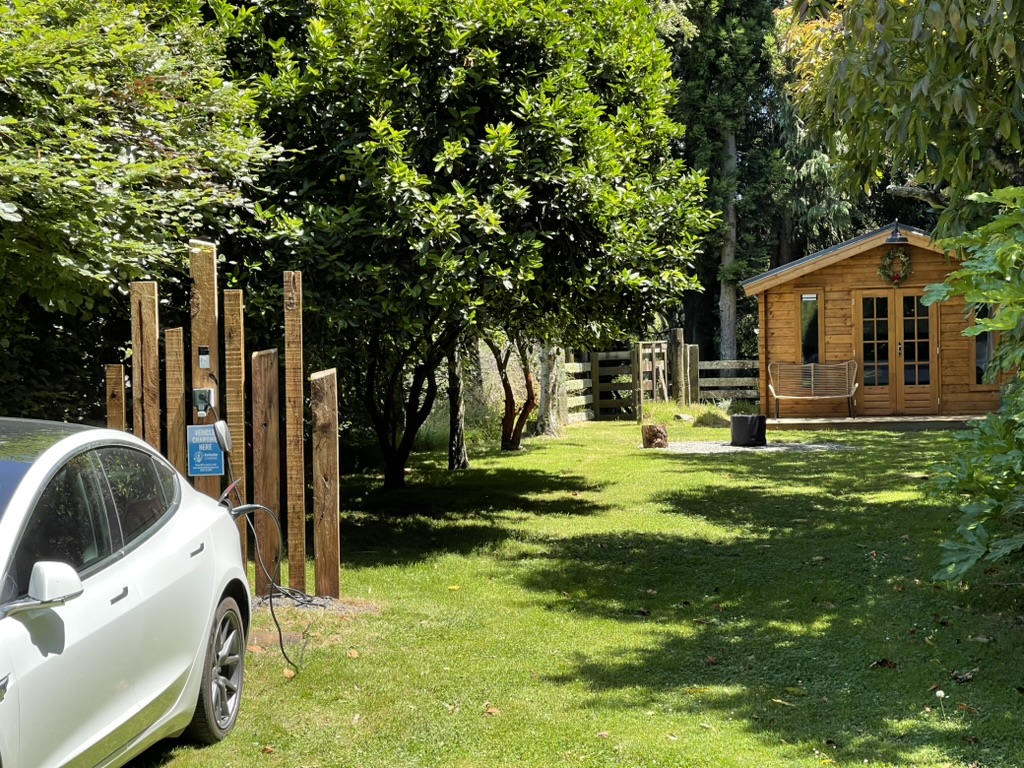 A car connected to the Destination Charge outlet at Journey’s Rest, with the cabin beyond